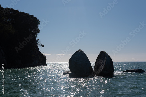 Split Apple Rock, or Tokangawha, shown in silhouette. This is a large granite boulder that has split down a natural joint in the rock. Tasman Bay, New Zealand.