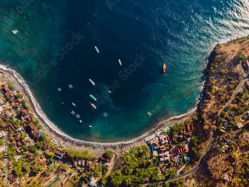Aerial view of Balinese town with blue sea and boats.