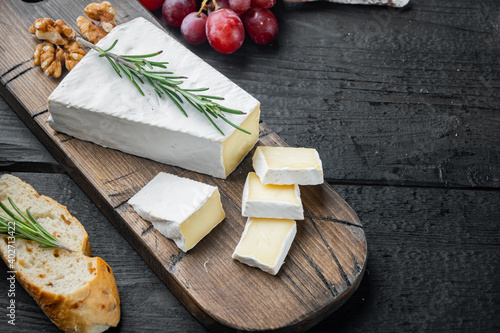 Delicious brie cheese, on black wooden table with copy space for text