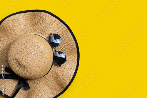 Summer hat with sunglasses on yellow background. Enjoy holiday concept.