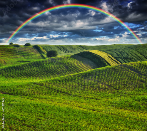 Scenic view of rainbow over green field 