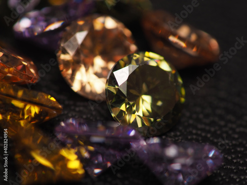 Close up shoot of beautiful, shiny, multi colored diamonds crystal gemstones, shoot on black leather as background