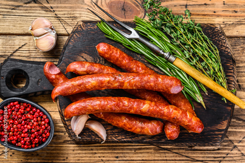 Pork Smoked sausages with addition of fresh aromatic herbs and spices. wooden background. Top view