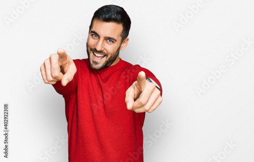 Young hispanic man wearing casual clothes pointing to you and the camera with fingers, smiling positive and cheerful