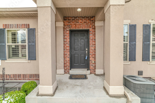 House entrance with portico leading to front door against red brick wall