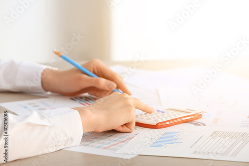 Female accountant with calculator in office, closeup