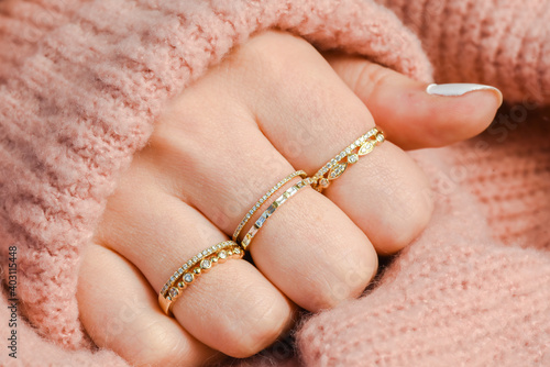 Hand with stackable rings and sweater