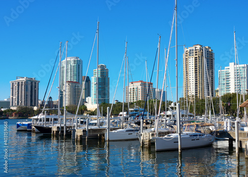 Sunny, clear, blue sky morning in Saint Petersburg, Florida, showing the skyline with sailboats in the foreground with beautiful reflections on the water.