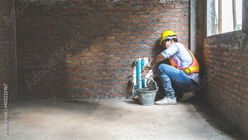 Man bricklayer installing bricks on construction site