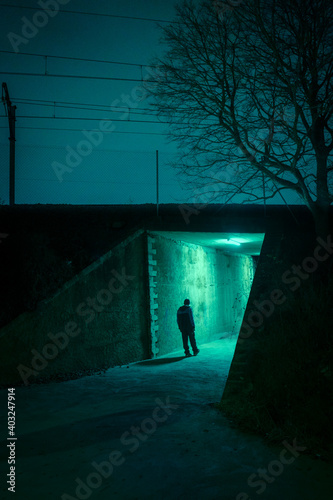 Lonely man in a dark alley at night. Danger and scary concept.