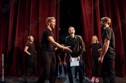 Working together. Group of actors in dark colored clothes on rehearsal in the theater