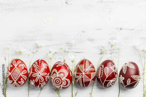 Row of red colored Easter eggs. Pysanka on white