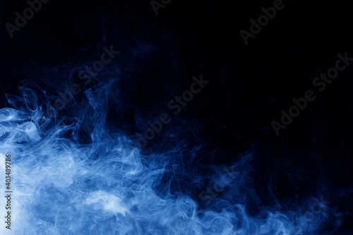 Abstract blue smoke moves on black background. Swirling smoke.