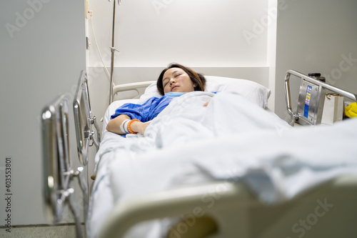 asian female patient sleeping on hospital bed with blanket covered.