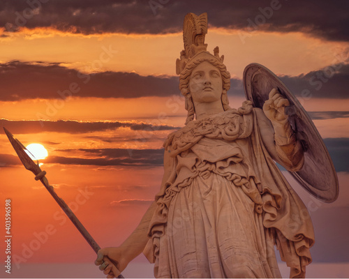 Athena statue the ancient Greek goddess of wisdom and knowledge illuminated by dramatic sun burned sky, Athens Greece