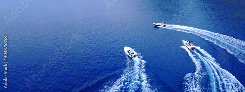 Aerial drone ultra wide top down photo of synchronised powerboats cruising in high speed in deep blue open ocean sea