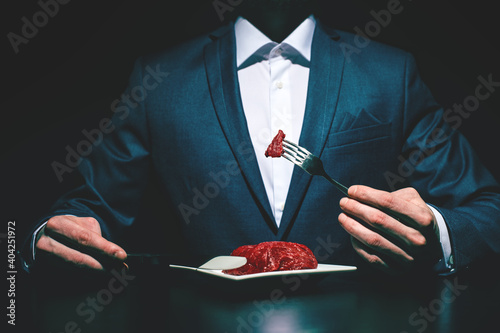 Supper of blue blood aristocrat. Portrait of handsome,young man eating fresh meat . Classical suit. Luxury style. Indoor shot - Image
