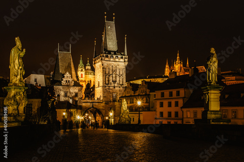 Night view of the illuminated St Nicolas church,Charles Bridge and Prague Castle,Czech republic.Night city scene.Long exposure city lights people in motion.Amazing European cityscape.Famous landmark.