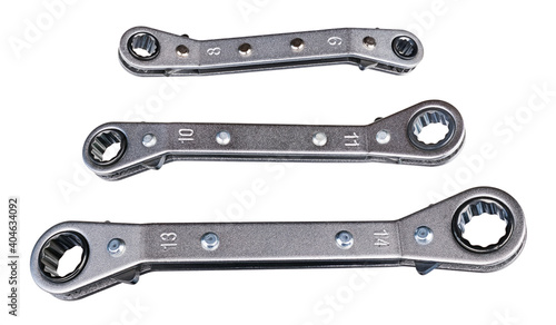 Set of ratcheting box-end wrenches or ring spanners isolated on white background. Close-up of double head ratchet handles. Three various sized metal hand tools for screwing and tightening nut or bolt.