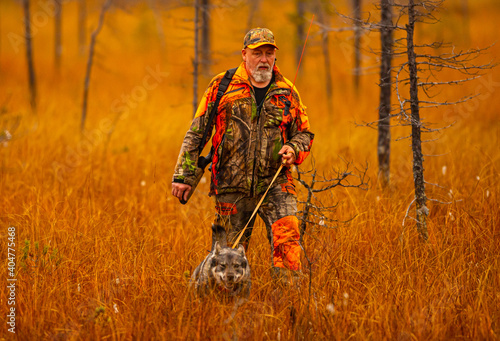 Hunter and his elkhound outdoor in the wilderness