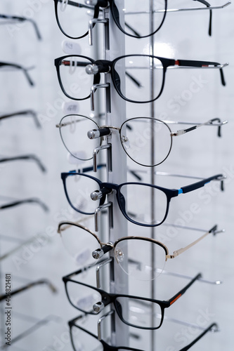 Row of glasses at an opticians. Eyeglasses shop. Stand with glasses in the store of optics. Showcase with spectacles in modern ophthalmic store. Closeup.
