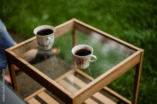 Dwie filiżanki kawy stojące na szklany stoliku 