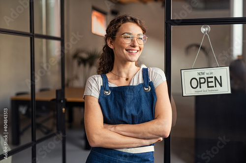 Small business owner standing at cafe entrance