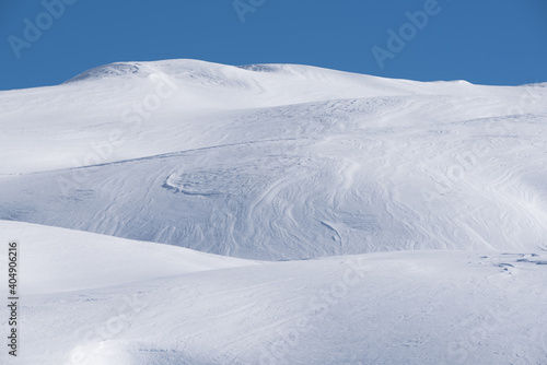 un bel paesaggio di montagna innevato, delle dune di neve in luce-ombra sembrano quasi un deserto.