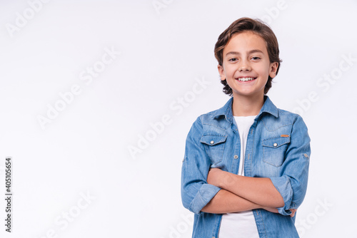 Happy young caucasian boy in casual outfit with arms crossed isolated over white background