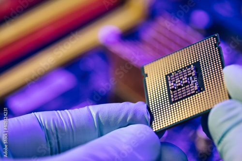 Computer support engineer installing processor. Microprocessor with clearly visible silicon core and cache chip. Installation of computer processor in the socket