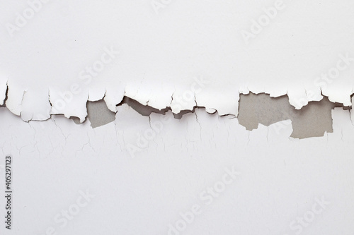 White color paint peeling off on ceiling house. Under the roof