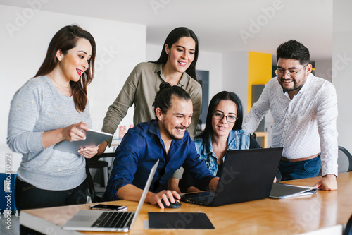 Group of latin business people working together as a teamwork while sitting at the office desk in a creative office in Mexico city