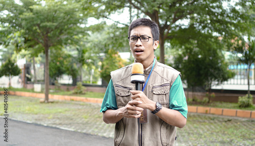asian male journalist wear vest and ready for news