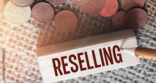 RESELLING word written on wooden building block and euro coins around. Trading reselling retail business concept