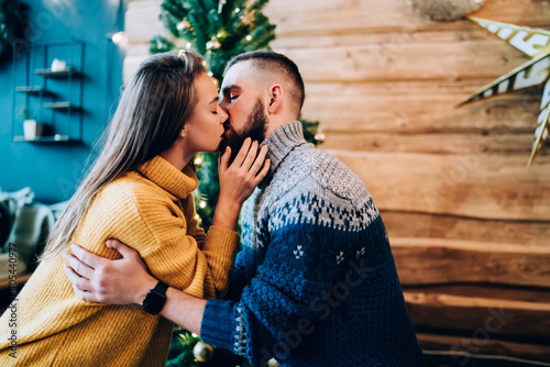 Amorous couple kissing in cozy sweaters