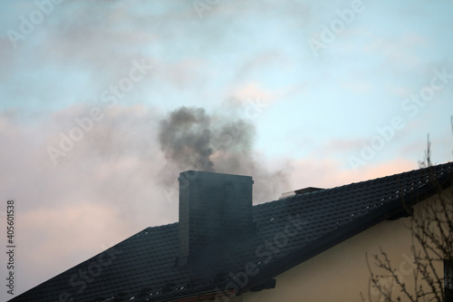 Dark smoke from a chimney from a single-family house