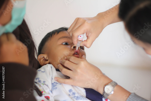 Nurse making infant oral vaccination against rotavirus infection. Children health care and disease prevention.
