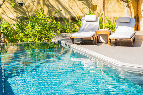 Umbrella and chair around outdoor swimming pool