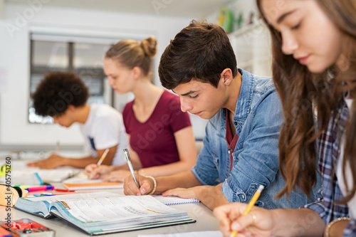 High school students doing exam in classroom