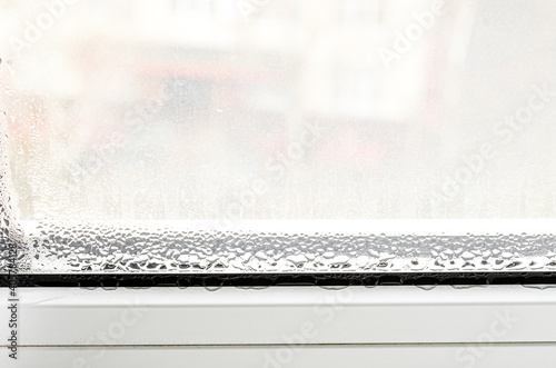 Drops of condensate on a white metal-plastic window