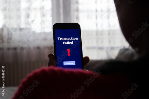 Transaction failed notification in a mobile phone screen. Close up of woman, girl using holding her mobile phone.