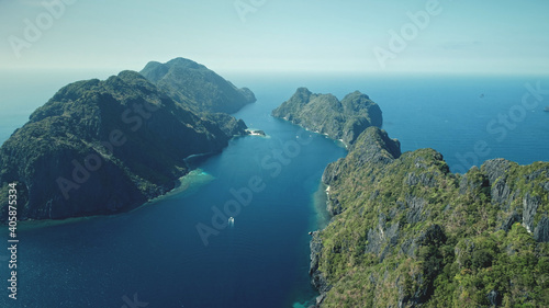 Vessels at sea bay of tropic islands aerial view. Amazing blue seascape at hilly isles with wild nature. Marine scenery of water transport with summer travel concept. Cinematic soft light drone shot