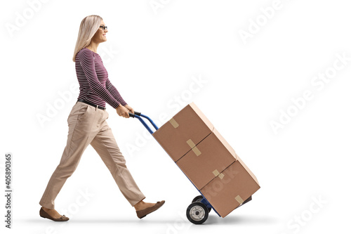 Woman walking and pushing a hand-truck with a pile of boxes