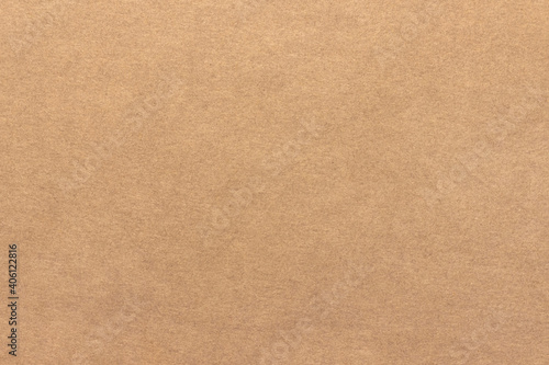 Light brown cardboard texture. Uniform beige background with small inclusions.