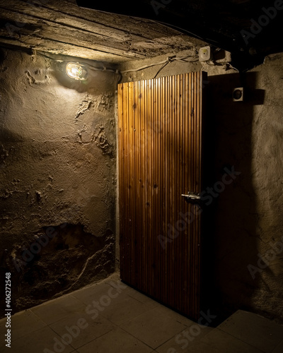 Mroczna piwnica tajemnicze drzwi pojedyncza lampka led słabe oświetlenie 