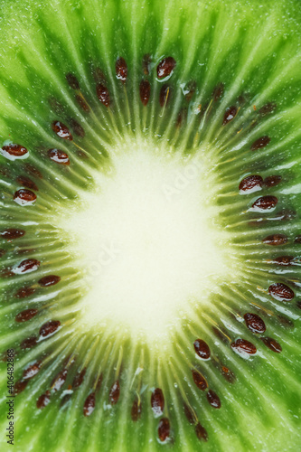 Slice of ripe kiwi fruit in full screen close-up.