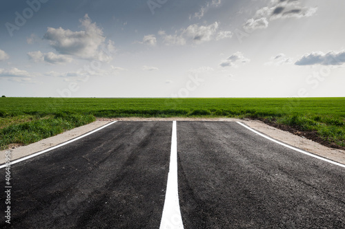 Dead end road in green field landscape