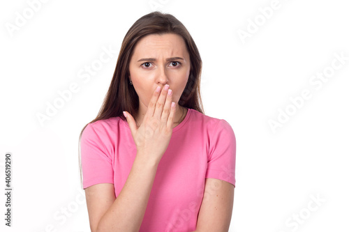 Secret. Surprised woman covering her face with her hands, isolated on white background. Female brunette in a pink sweater. Place for text.