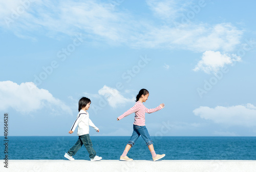 防波堤を歩く女の子と男の子
