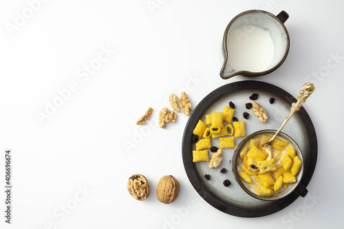 walnuts and raisins on the table next to milk and cornflakes in a cup